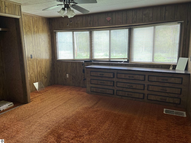 118 W Huron, Omer, MI 48749 - unfurnished bedroom featuring wood walls, carpet, ceiling fan, and a textured ceiling