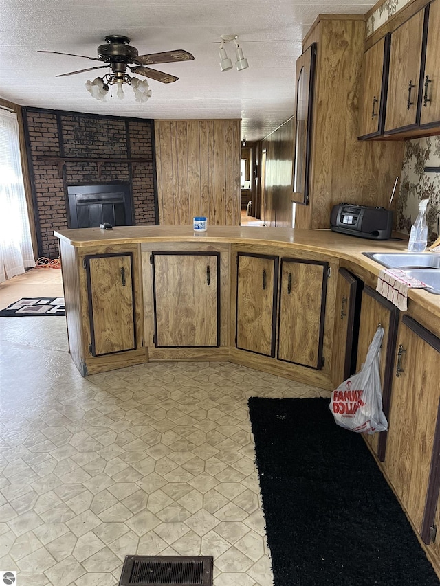 118 W Huron, Omer, MI 48749 - kitchen with ceiling fan, light countertops, a textured ceiling, brown cabinetry, and a peninsula