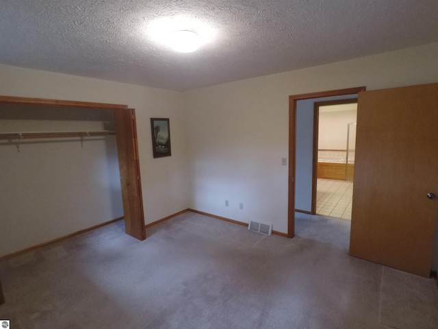 2118 E Lake Mitchell Dr, Cadillac, MI 49601 - unfurnished bedroom featuring a closet, a textured ceiling, carpet floors, and baseboards