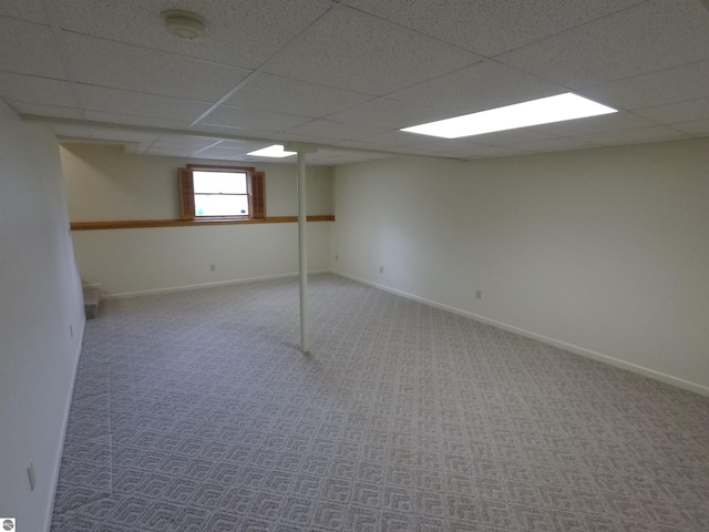 2118 E Lake Mitchell Dr, Cadillac, MI 49601 - below grade area with a paneled ceiling, carpet, and baseboards