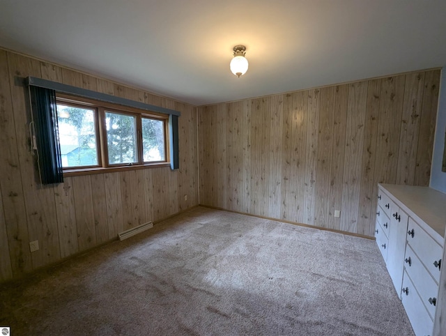 1082 S Sixth St, Au Gres, MI 48703 - carpeted empty room featuring a baseboard heating unit and wood walls