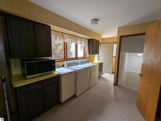 1082 S Sixth St, Au Gres, MI 48703 - kitchen with black microwave, light countertops, washing machine and clothes dryer, light carpet, and wallpapered walls