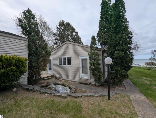 1082 S Sixth St, Au Gres, MI 48703 - back of house featuring a yard and a water view