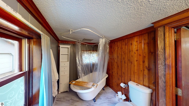 605 Cedar Ave, Houghton Lake, MI 48651 - full bath with marble look tile flooring, wooden walls, toilet, a textured ceiling, and shower / bathtub combination with curtain