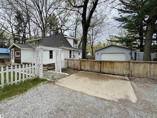 605 Cedar Ave, Houghton Lake, MI 48651 - view of side of property with a garage, an outbuilding, and a shingled roof