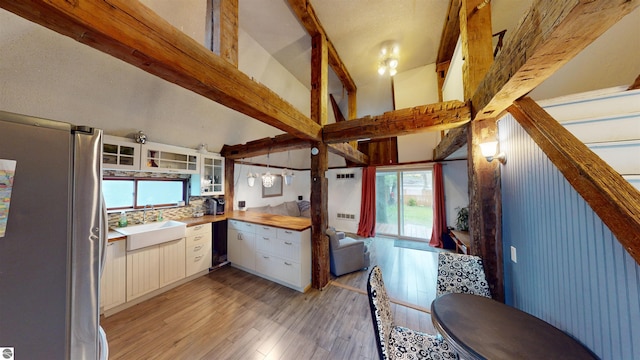 605 Cedar Ave, Houghton Lake, MI 48651 - kitchen with freestanding refrigerator, a sink, light wood-style floors, light countertops, and beam ceiling