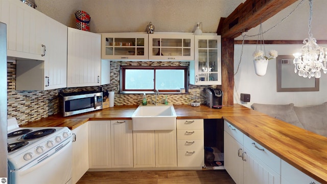 605 Cedar Ave, Houghton Lake, MI 48651 - kitchen featuring wooden counters, stainless steel microwave, white electric range oven, tasteful backsplash, and a textured ceiling