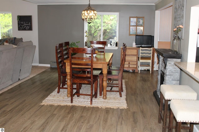 3690 Rau Rd, West Branch, MI 48661 - dining area with crown molding, wood finished floors, a chandelier, a baseboard heating unit, and baseboards