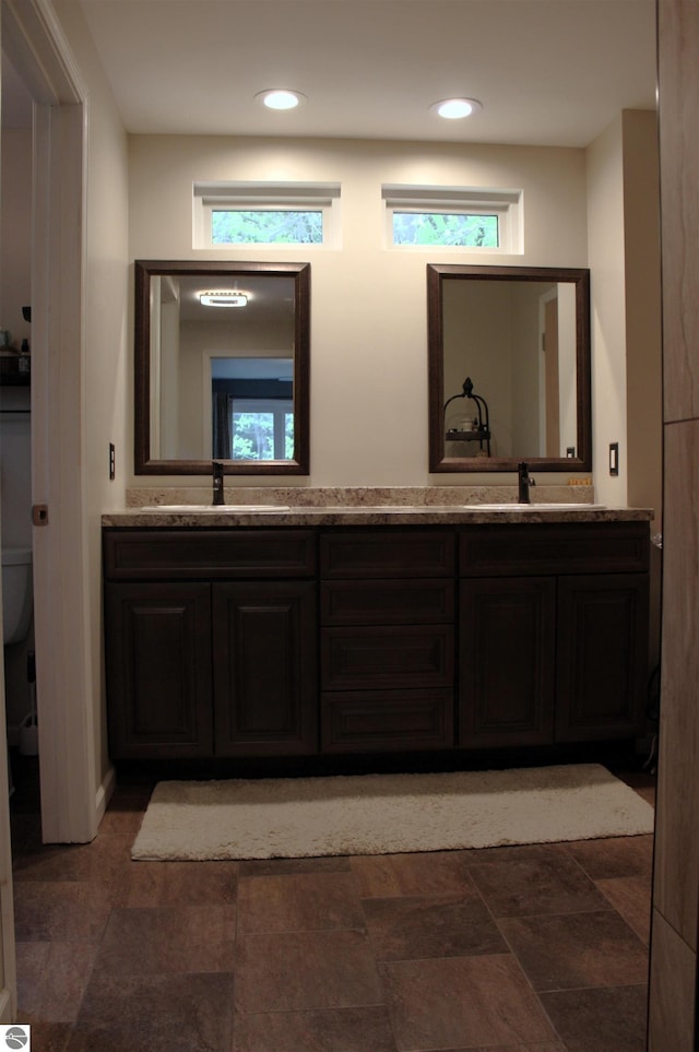 3690 Rau Rd, West Branch, MI 48661 - bathroom with toilet, double vanity, stone finish floors, and recessed lighting