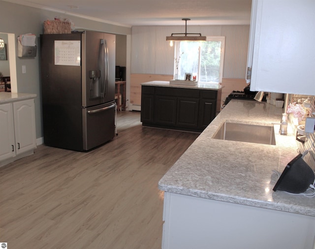 3690 Rau Rd, West Branch, MI 48661 - kitchen with stainless steel fridge, a baseboard heating unit, light wood-style flooring, ornamental molding, and decorative light fixtures