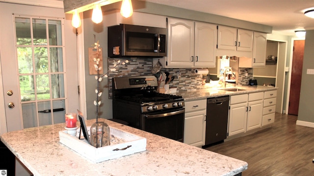 3690 Rau Rd, West Branch, MI 48661 - kitchen with stainless steel appliances, a sink, tasteful backsplash, wood finished floors, and white cabinetry