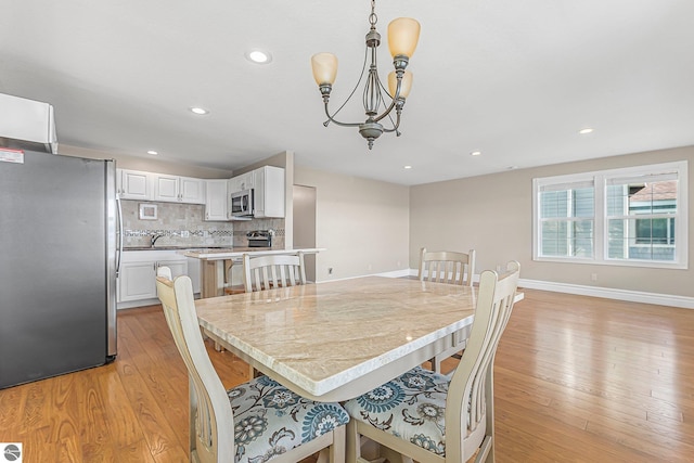 3151 W Lake Mitchell Dr, Cadillac, MI 49601 - dining room featuring light wood-type flooring, a chandelier, recessed lighting, and baseboards