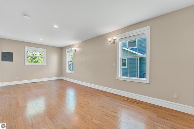 3151 W Lake Mitchell Dr, Cadillac, MI 49601 - spare room featuring baseboards, electric panel, light wood-style flooring, and recessed lighting