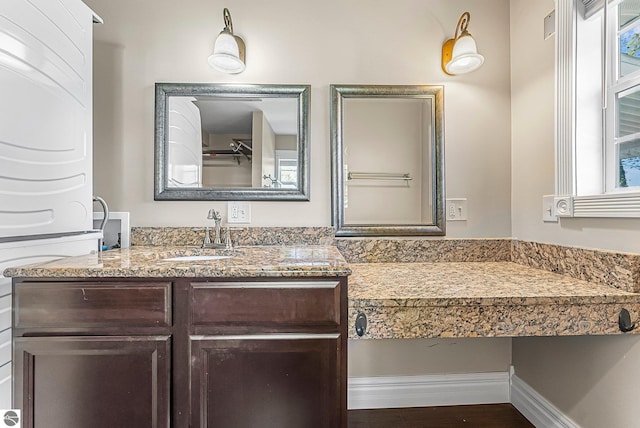 3151 W Lake Mitchell Dr, Cadillac, MI 49601 - bathroom with vanity and stacked washing machine and dryer