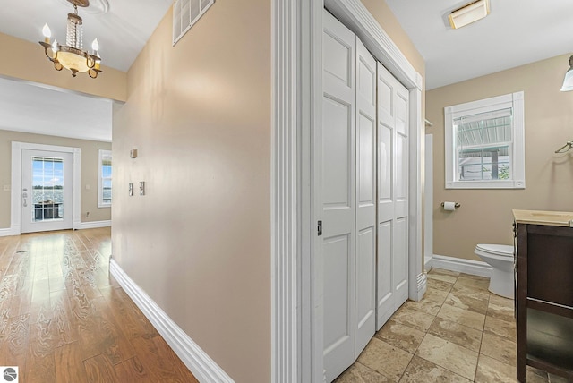 3151 W Lake Mitchell Dr, Cadillac, MI 49601 - hall featuring baseboards and a chandelier