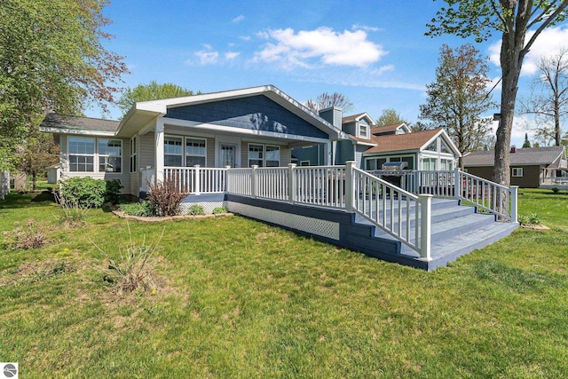 3151 W Lake Mitchell Dr, Cadillac, MI 49601 - rear view of house featuring a lawn and a porch