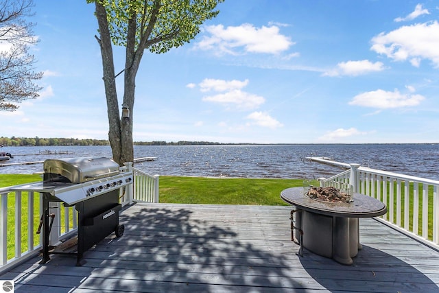 3151 W Lake Mitchell Dr, Cadillac, MI 49601 - deck with an outdoor fire pit, a water view, grilling area, and a yard