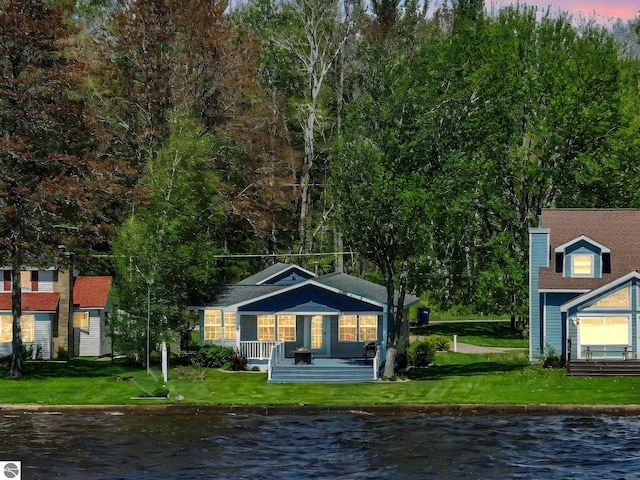 3151 W Lake Mitchell Dr, Cadillac, MI 49601 - back of property with a water view, covered porch, and a yard