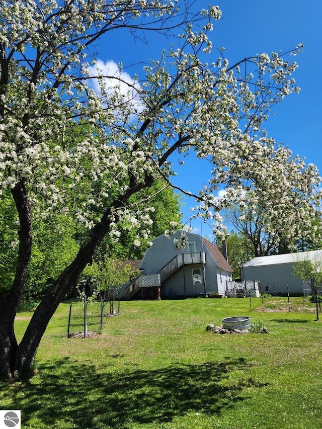 6878 Boss Rd, Ellsworth, MI 49727 - view of green lawn featuring stairs and a wooden deck