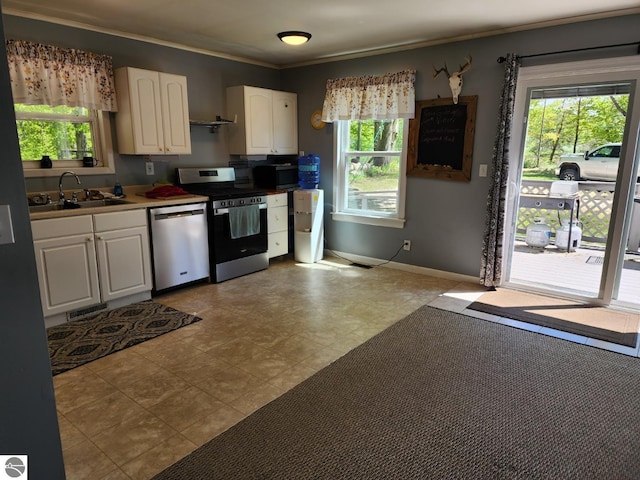6878 Boss Rd, Ellsworth, MI 49727 - kitchen with stainless steel appliances, a sink, white cabinets, ornamental molding, and baseboards