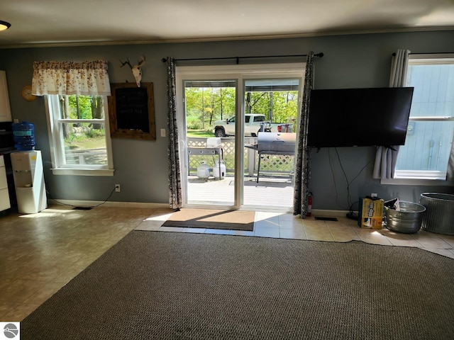 6878 Boss Rd, Ellsworth, MI 49727 - doorway to outside featuring tile patterned flooring, plenty of natural light, ornamental molding, and baseboards