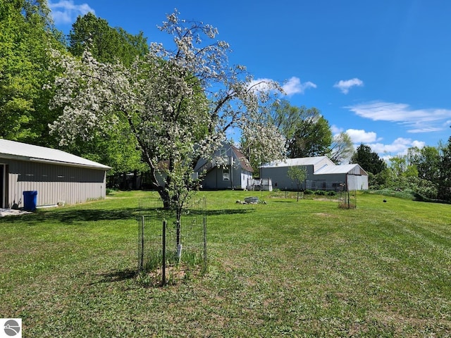 6878 Boss Rd, Ellsworth, MI 49727 - view of grassy yard featuring a pole building and an outdoor structure