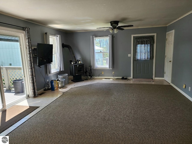6878 Boss Rd, Ellsworth, MI 49727 - foyer entrance with a wood stove, tile patterned flooring, ceiling fan, ornamental molding, and baseboards