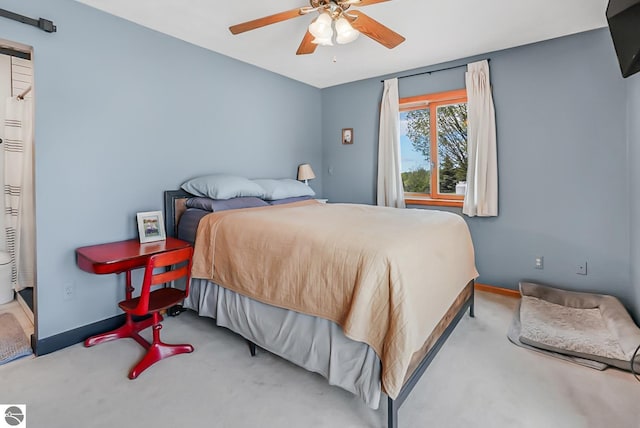8281 M-66, Fife Lake, MI 49633 - carpeted bedroom with baseboards, a barn door, and a ceiling fan