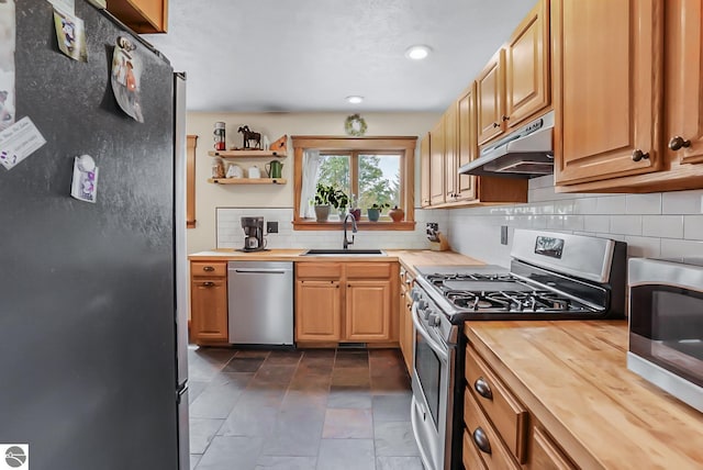 8281 M-66, Fife Lake, MI 49633 - kitchen featuring stainless steel appliances, a sink, under cabinet range hood, butcher block counters, and tasteful backsplash