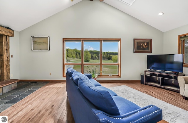 8281 M-66, Fife Lake, MI 49633 - living area with healthy amount of natural light, baseboards, wood finished floors, high vaulted ceiling, and recessed lighting