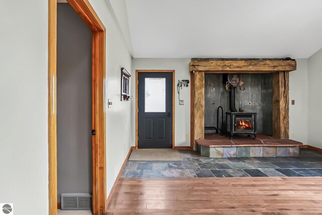8281 M-66, Fife Lake, MI 49633 - foyer entrance with a wood stove, wood finished floors, and baseboards