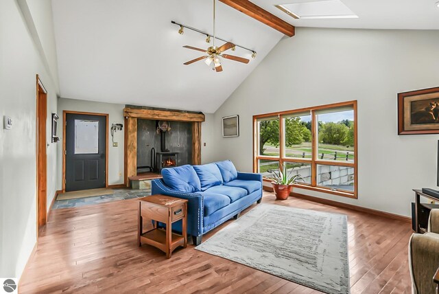 8281 M-66, Fife Lake, MI 49633 - living area with a skylight, high vaulted ceiling, beam ceiling, wood finished floors, and a ceiling fan