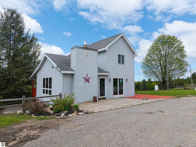 8281 M-66, Fife Lake, MI 49633 - view of front facade featuring a shingled roof, a wooden deck, and a chimney