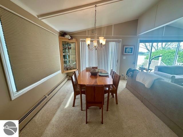 1094 Fairway Dr, Lake Isabella, MI 48893 - dining space featuring vaulted ceiling, a chandelier, light colored carpet, and a baseboard radiator