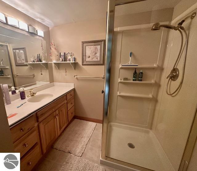 1094 Fairway Dr, Lake Isabella, MI 48893 - bathroom with vanity, a stall shower, and tile patterned flooring