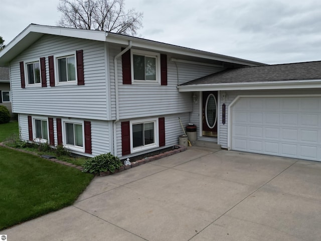 1094 Fairway Dr, Lake Isabella, MI 48893 - split level home featuring concrete driveway and an attached garage