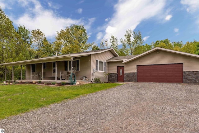 605 E M-55, West Branch, MI 48661 - view of front of property featuring driveway, a porch, a garage, and a front lawn