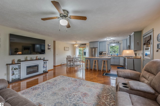 605 E M-55, West Branch, MI 48661 - living area featuring ceiling fan, a textured ceiling, and wood finished floors