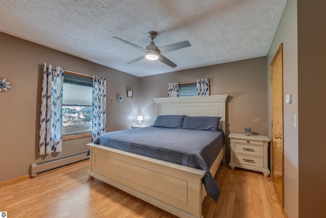 605 E M-55, West Branch, MI 48661 - bedroom with baseboard heating, light wood-style flooring, a textured ceiling, and ceiling fan