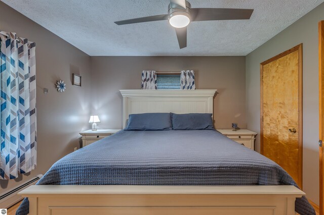605 E M-55, West Branch, MI 48661 - bedroom with a baseboard radiator, a textured ceiling, and ceiling fan