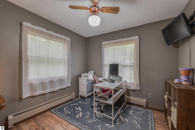 605 E M-55, West Branch, MI 48661 - home office featuring a baseboard radiator, a textured ceiling, wood finished floors, a ceiling fan, and baseboards