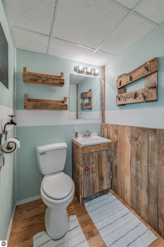 605 E M-55, West Branch, MI 48661 - bathroom with a drop ceiling, toilet, wood finished floors, and vanity