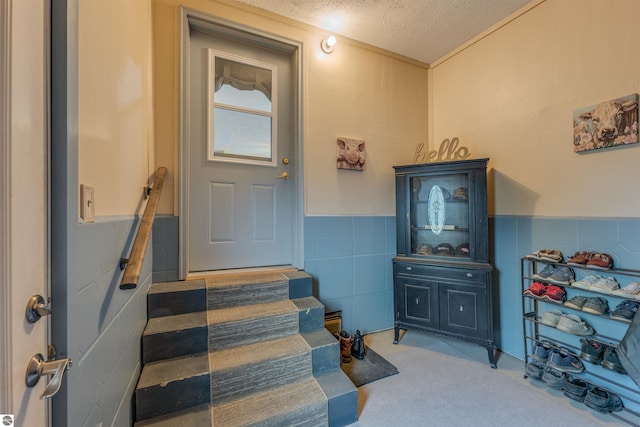 605 E M-55, West Branch, MI 48661 - stairs featuring tile walls, a wainscoted wall, and a textured ceiling
