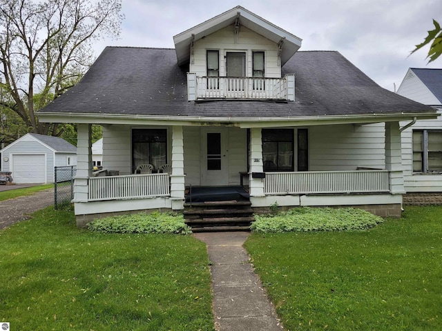 415 Elwell St, Alma, MI 48801 - bungalow-style house featuring a porch, a balcony, a front yard, and an outbuilding