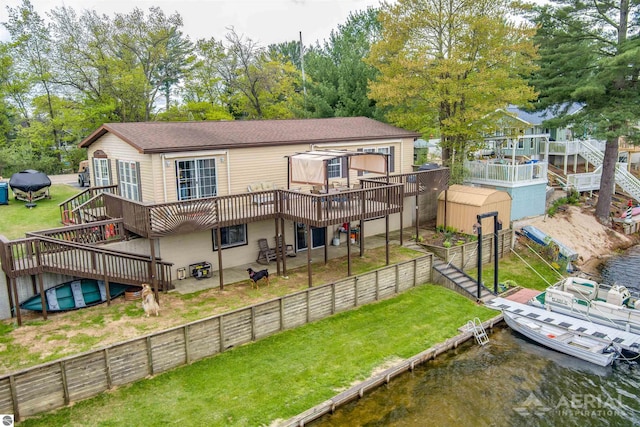 1929 Mohawk Trl, West Branch, MI 48661 - back of house with a deck with water view, stairway, a shingled roof, and view of scattered trees