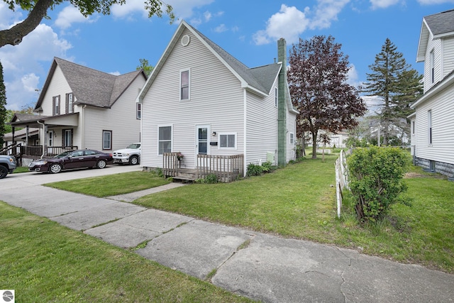 832 Wallace St, Cadillac, MI 49601 - view of front of property featuring a chimney, a front yard, and a shingled roof