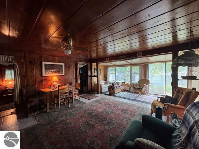 951 Lake Dr, Harrison, MI 48625 - living area with wood ceiling, ceiling fan, and wooden walls