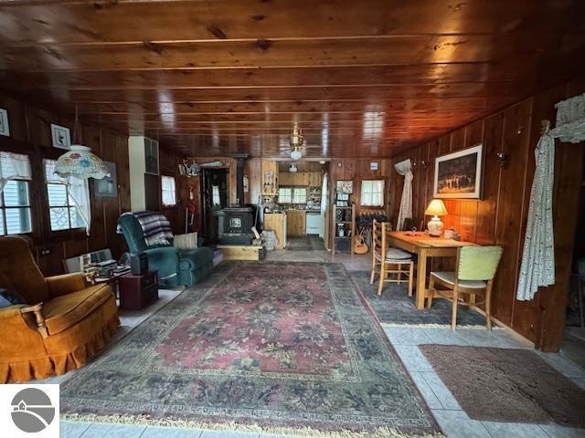 951 Lake Dr, Harrison, MI 48625 - living area with wood ceiling, wooden walls, and a wood stove