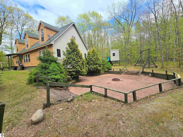 1470 N Al Moses Rd, Lake City, MI 49651 - view of side of home with an outdoor fire pit and a yard
