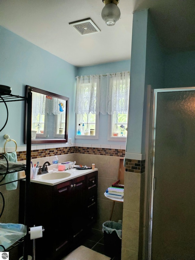 1148 Horseshoe Dr, Alger, MI 48610 - bathroom with vanity, tile walls, a stall shower, wainscoting, and tile patterned floors